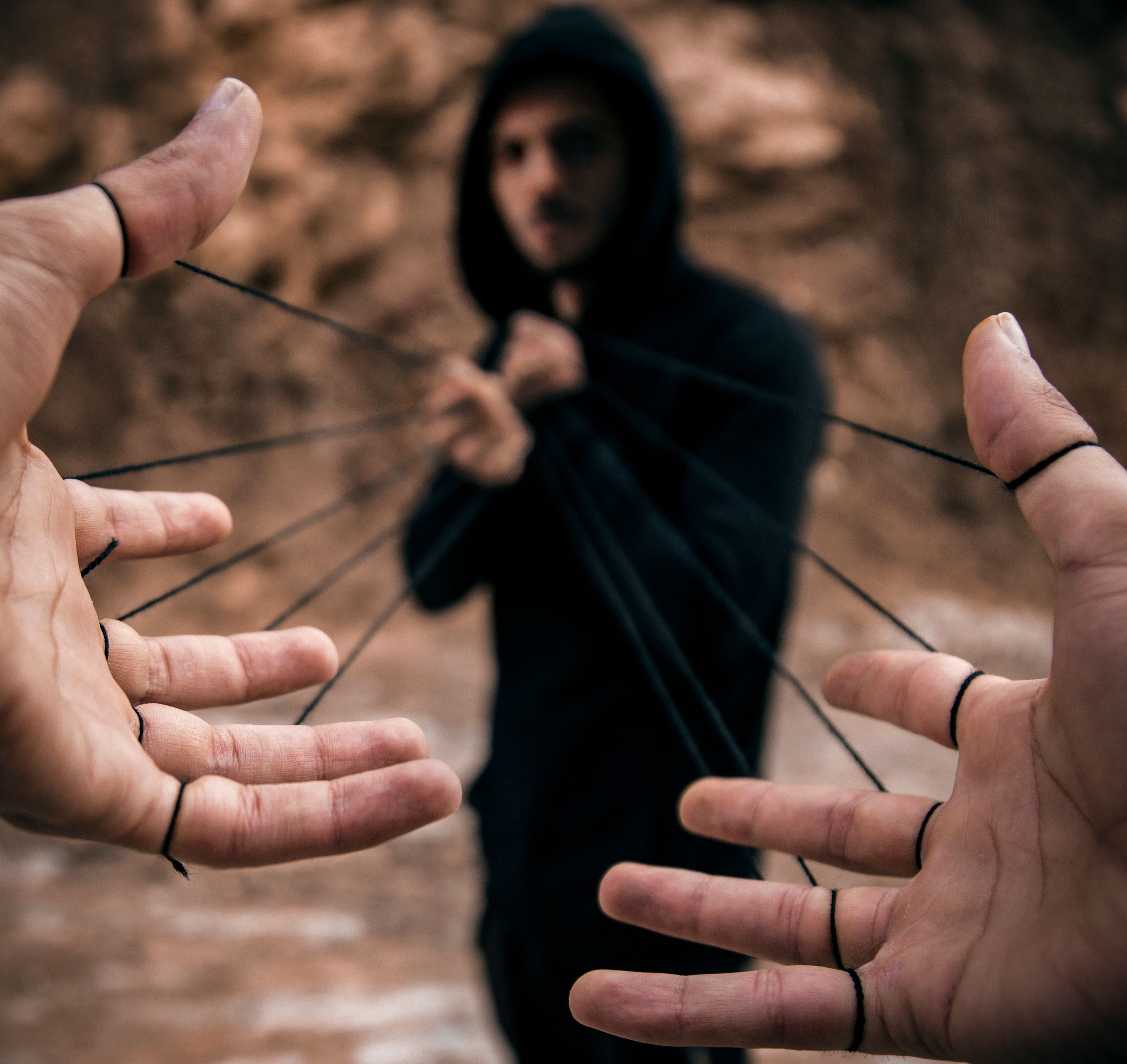 Conceptual image of a man controlling hands with strings, illustrating manipulation and control by a self-serving leader