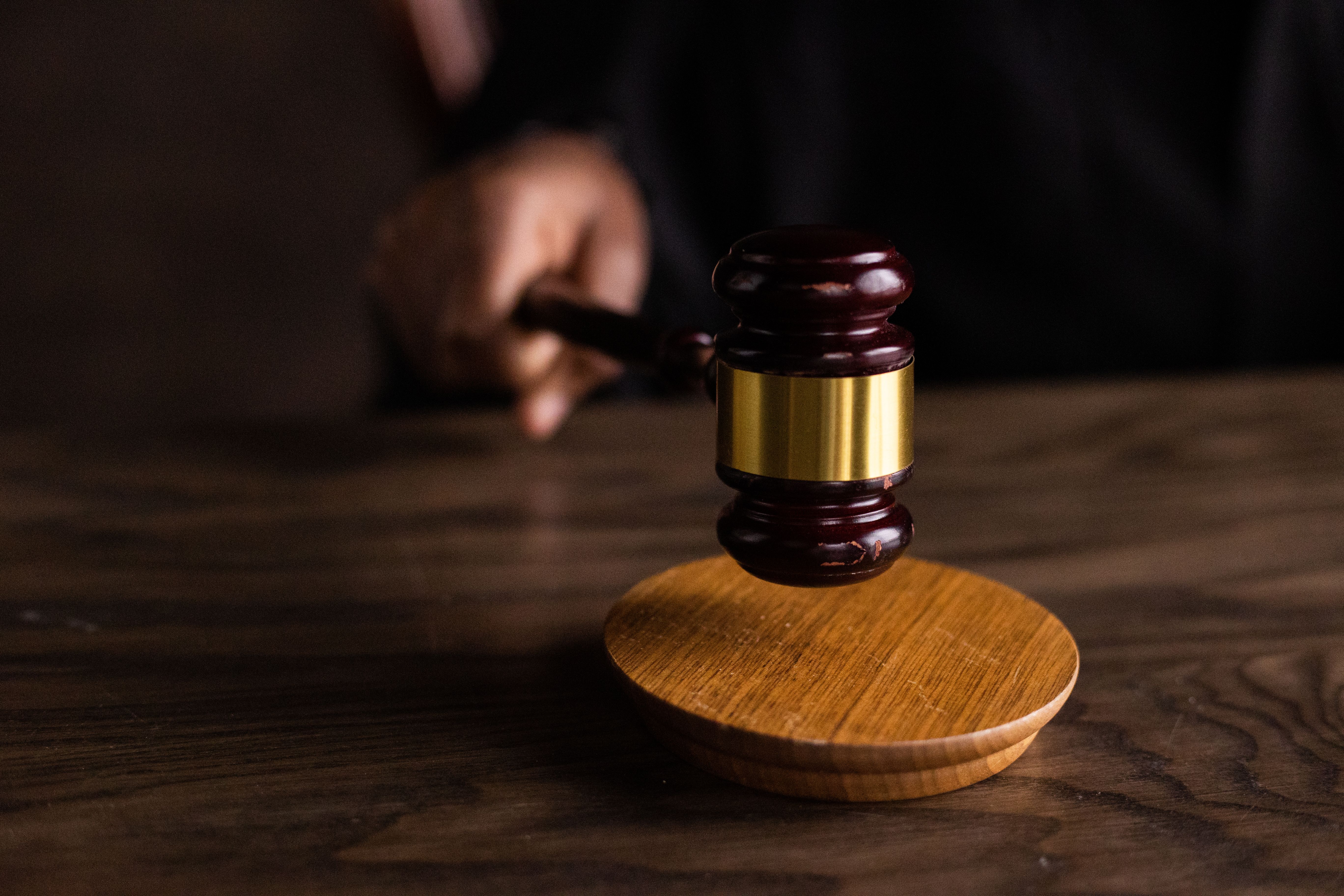 A gavel striking a sound block in a courtroom, symbolizing lawsuits and legal authority